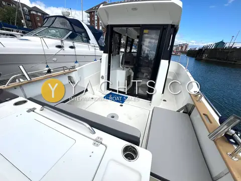 Jeanneau Merry Fisher 795 Marlin: cockpit looking forward to open sliding glass doors into the wheelhouse, teak-capped gunwales