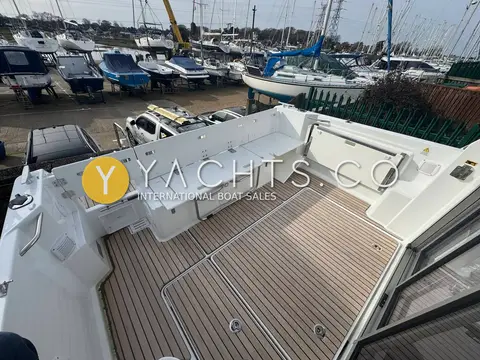 Jeanneau Merry Fisher 795 S2: aft cockpit with teak floor and bench seating, marina boatyard in background