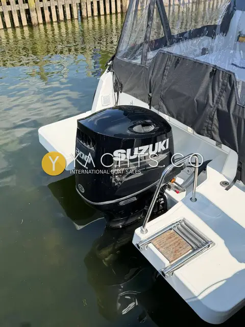 Jeanneau Merry Fisher 795 S2: stern view of the black Suzuki outboard between bathing platforms with a stainless swim ladder