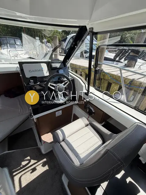 Jeanneau Merry Fisher 795 S2: helm station with Garmin display, wheel and grey upholstered helm seat