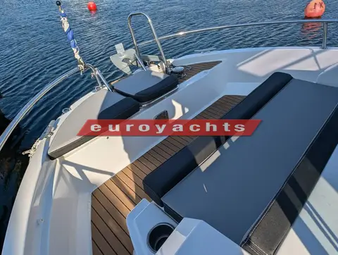 Jeanneau Merry Fisher 795 Sport S2: forward cockpit with dark cushions, synthetic teak decking and bow rail