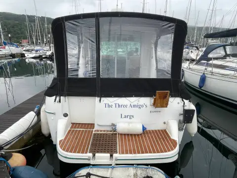 Jeanneau Merry Fisher 805: stern with enclosed cockpit canopy, teak-effect swim platform flooring and Largs home port lettering