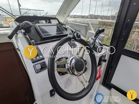 Jeanneau Merry Fisher 855: helm station with chrome-spoked wheel, chartplotter screen and throttle lever