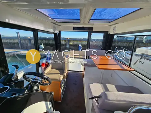 Jeanneau Merry Fisher 895: wheelhouse interior looking forward past the helm to the dinette and twin roof windows