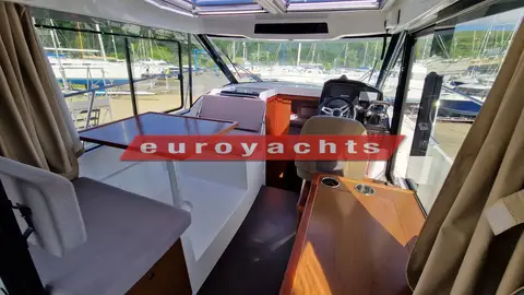 Jeanneau Merry Fisher 895 Offshore: wheelhouse with dining table and seating to port, helm seat to starboard