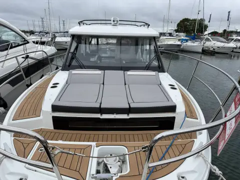 Jeanneau Merry Fisher 895 S2: foredeck with grey bow sunbed cushions and teak-effect decking ahead of the windscreen