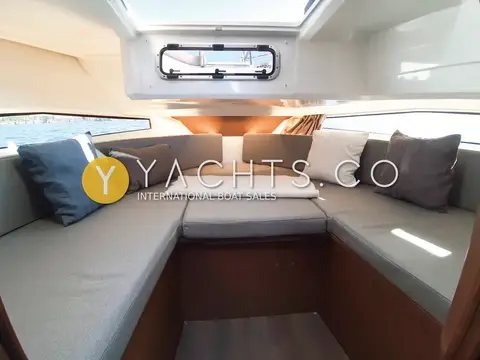 Jeanneau Merry Fisher 895 Sport Offshore: forward cabin with U-shaped grey upholstered berth, scatter cushions and overhead hatch