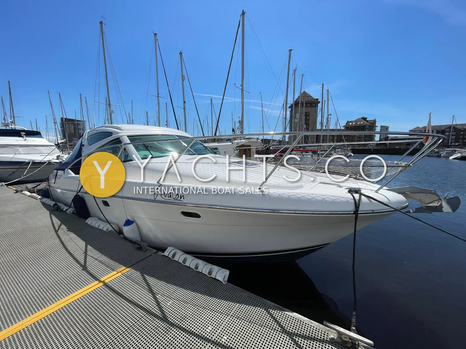 Jeanneau Prestige 34S: starboard bow view of the white hull berthed at a sunny marina pontoon