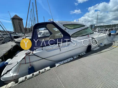 Jeanneau Prestige 34S: port side profile with navy cockpit canopy fitted, moored in the marina