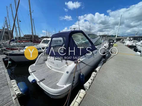 Jeanneau Prestige 34S: stern quarter view showing teak bathing platform and navy enclosed canopy