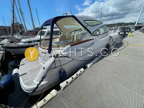Jeanneau Prestige 34S: port quarter view with canopy rolled back revealing cockpit seating and table