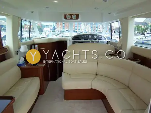 Jeanneau Prestige 36: saloon with cream leatherette U-shaped seating, opposite settee and lower helm forward