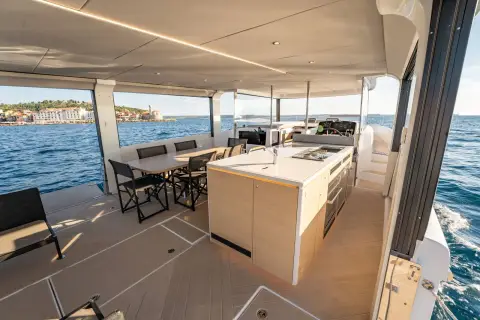 Jeanneau Sea Loft 480: main deck galley island with dining table beyond and wide open sides to the sea