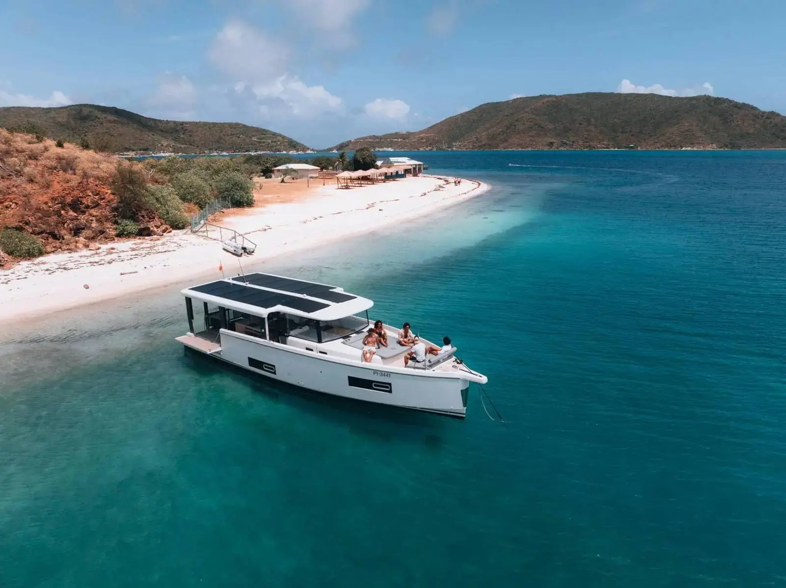 Jeanneau Sea Loft 480: aerial view of the boat at anchor in turquoise water off a sandy beach