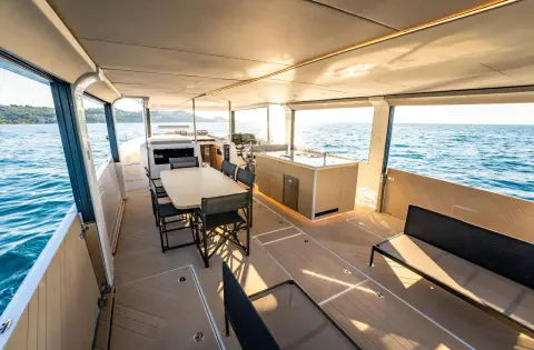 Jeanneau Sea Loft 480: full-length main deck view showing dining table, galley and sofa under the hardtop