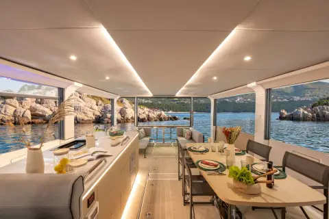 Jeanneau Sea Loft 480: open main deck with galley counter and dining table, glass sides open to the sea