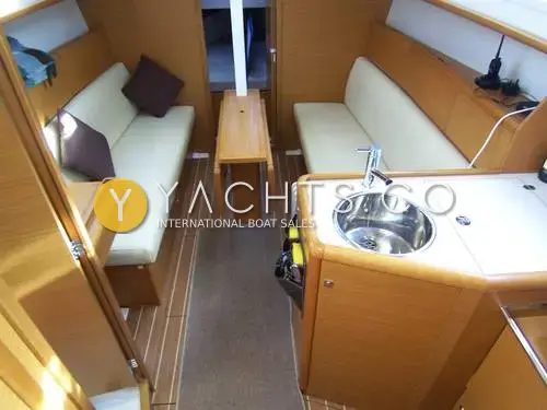 Jeanneau Sun Odyssey 30I: saloon with cream settees either side, folding table and galley sink in light wood