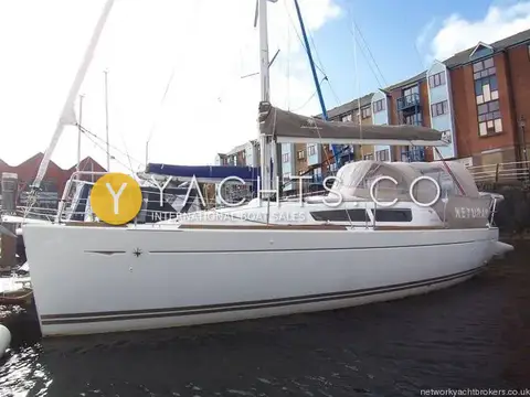 Jeanneau Sun Odyssey 30I: white hull alongside in marina with brown boom cover and cockpit enclosure