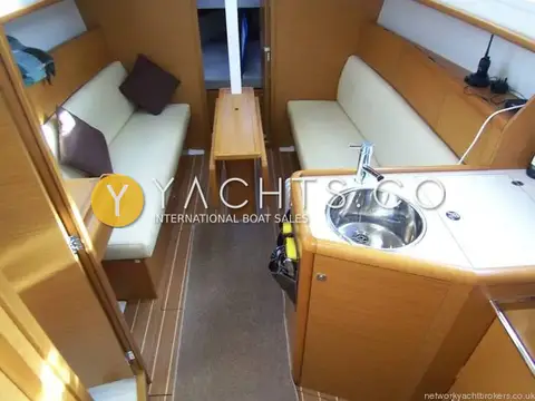 Jeanneau Sun Odyssey 30I: saloon and galley looking forward, wood trim, teak-effect sole and handheld VHF