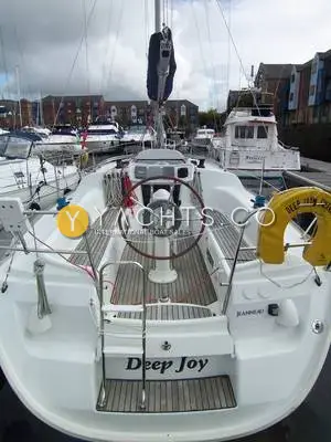 Jeanneau Sun Odyssey 32 Legend: cockpit seen from the stern with wheel, teak seating and Deep Joy name on the transom step