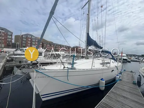 Jeanneau Sun Odyssey 34.2: starboard side view afloat in the marina with mainsail in its stack pack