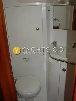 Jeanneau Sun Odyssey 34.2: heads compartment with manual toilet, corner washbasin, mirror and white moulded cabinet