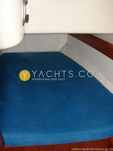 Jeanneau Sun Odyssey 34.2: double berth with blue cushion tucked beneath moulding in an aft cabin