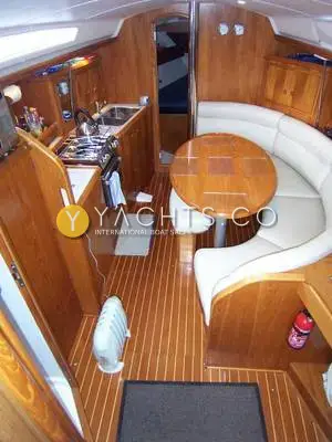 Jeanneau Sun Odyssey 34.2: saloon from the companionway showing cream curved seating, oval table and galley to port
