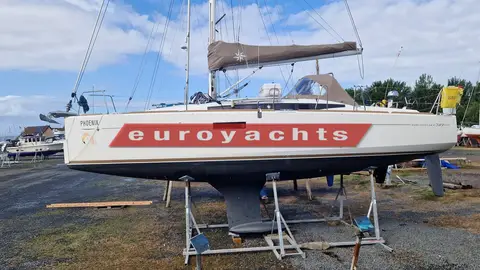 Jeanneau Sun Odyssey 349: starboard side of the hull ashore on stands, showing the fixed keel and furled mainsail