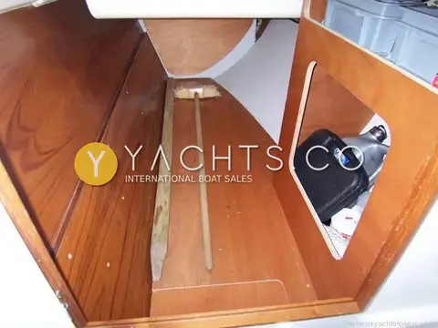 Jeanneau Sun Odyssey 35: large varnished wood stern stowage locker with brush and storage boxes inside