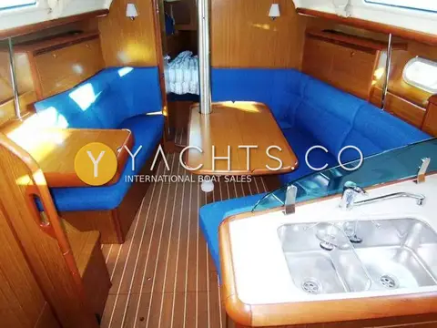 Jeanneau Sun Odyssey 35 Yacht For Sale: saloon with blue upholstery, folding wooden table, teak-and-holly sole and view forward to cabin