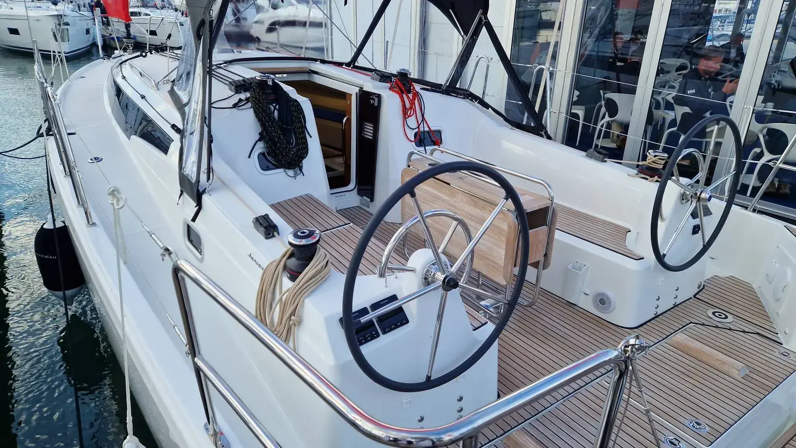 Jeanneau Sun Odyssey 350: cockpit with twin wheels, teak-laid seats and sole, seen from the side deck