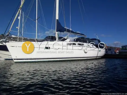 Jeanneau Sun Odyssey 37: white hull afloat in a marina berth, sail cover on the boom, under clear blue sky