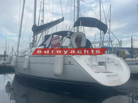 Jeanneau Sun Odyssey 37 Legende: stern quarter view at berth showing spray hood and stowed mainsail