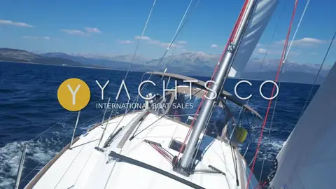 Jeanneau Sun Odyssey 389: foredeck view under sail with sprayhood, red halyards and mountains across open water