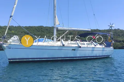 Jeanneau Sun Odyssey 40.3: port side of the hull at anchor, with bimini, stern arch and paddleboard on deck