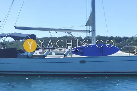 Jeanneau Sun Odyssey 40.3: side deck and coachroof with blue paddleboard lashed to the guardrails and fenders out
