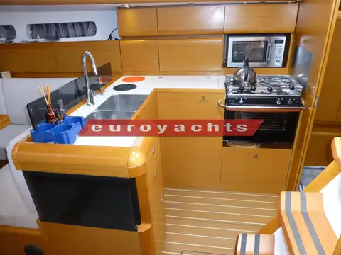 Jeanneau Sun Odyssey 409: galley with twin stainless sinks, two-burner stove with oven, and microwave above