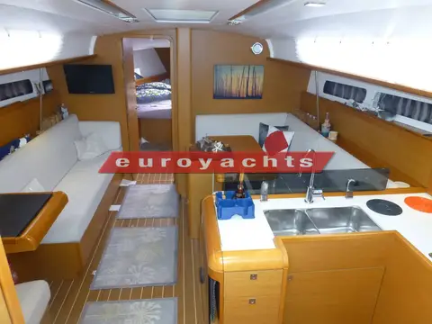 Jeanneau Sun Odyssey 409: wide view of the saloon with settees either side and galley in the foreground