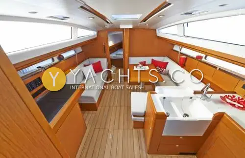 Jeanneau Sun Odyssey 41DS: saloon looking forward with teak-effect sole, white upholstery, galley sink and chart table