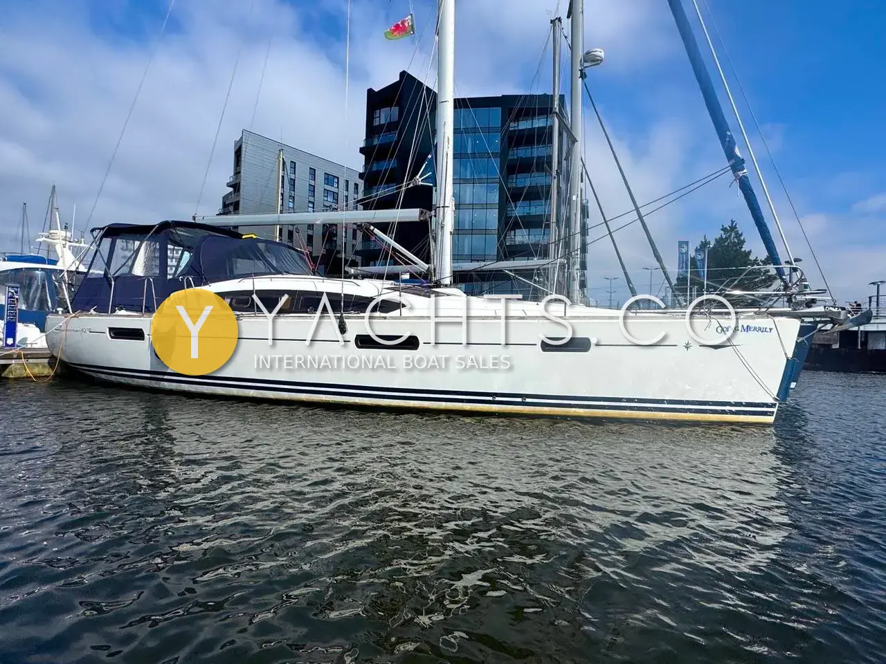 Jeanneau Sun Odyssey 42 DS: white deck saloon yacht moored in a marina beside modern apartment blocks
