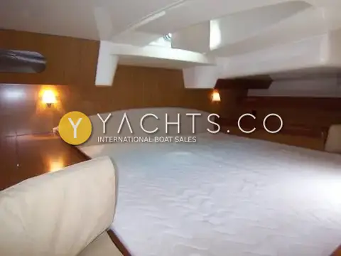 Jeanneau Sun Odyssey 42DS: aft cabin with large centreline double berth, white mattress cover and wall lamps lit