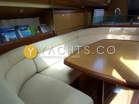 Jeanneau Sun Odyssey 42DS: saloon U-shaped seating in cream suede around a varnished wooden table
