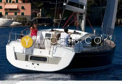 Jeanneau Sun Odyssey 44 DS: stern quarter under way, showing twin helms, cockpit table and dark blue hull