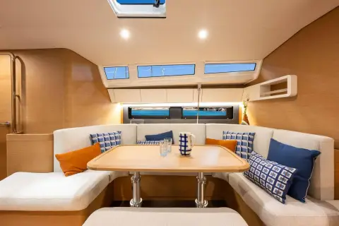 Jeanneau Sun Odyssey 455: u-shaped saloon settee around wooden table beneath long coachroof windows