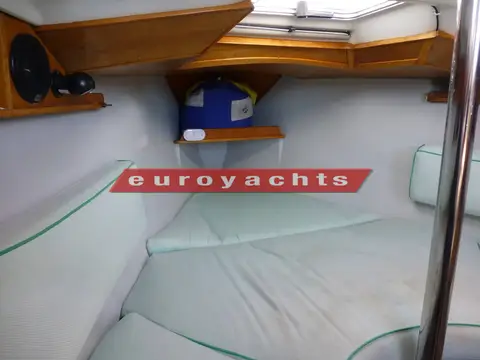 Jeanneau Sunway 25: forward V double berth with pale cushions and wooden shelving