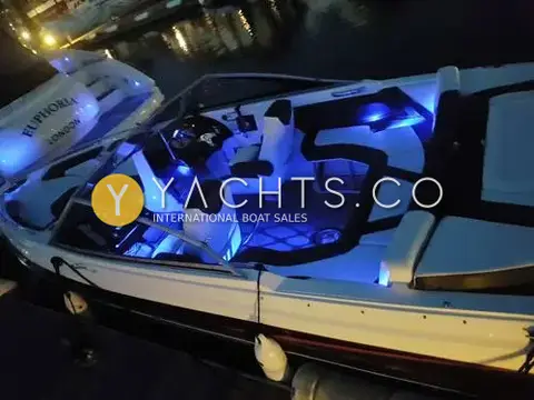 Larson 2300 LSR: cockpit at night lit by blue courtesy lighting, moored beside a larger motor yacht