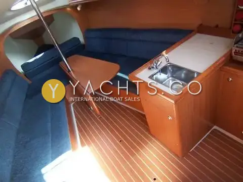 Legend 27: saloon with blue upholstery, folding table and galley sink on a teak-effect sole