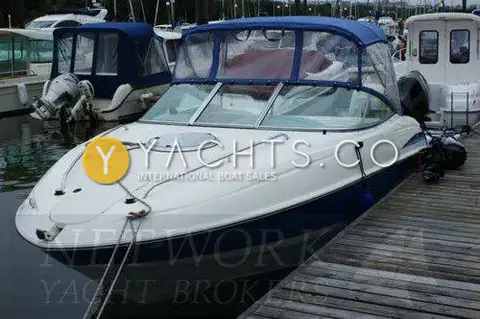 Maxum 2100 SC: bow and foredeck with hatch, blue canopy fitted, moored alongside a marina pontoon