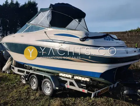 Maxum 2300 SC: starboard bow view on the trailer showing the Maxum hull graphics and dark canopy